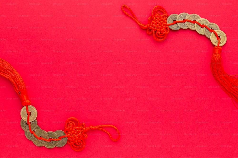 eine rot-silberne Halskette auf rosa Hintergrund