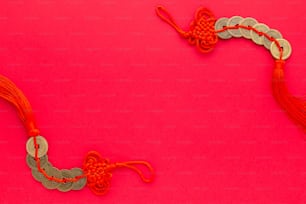 a red and silver necklace on a pink background