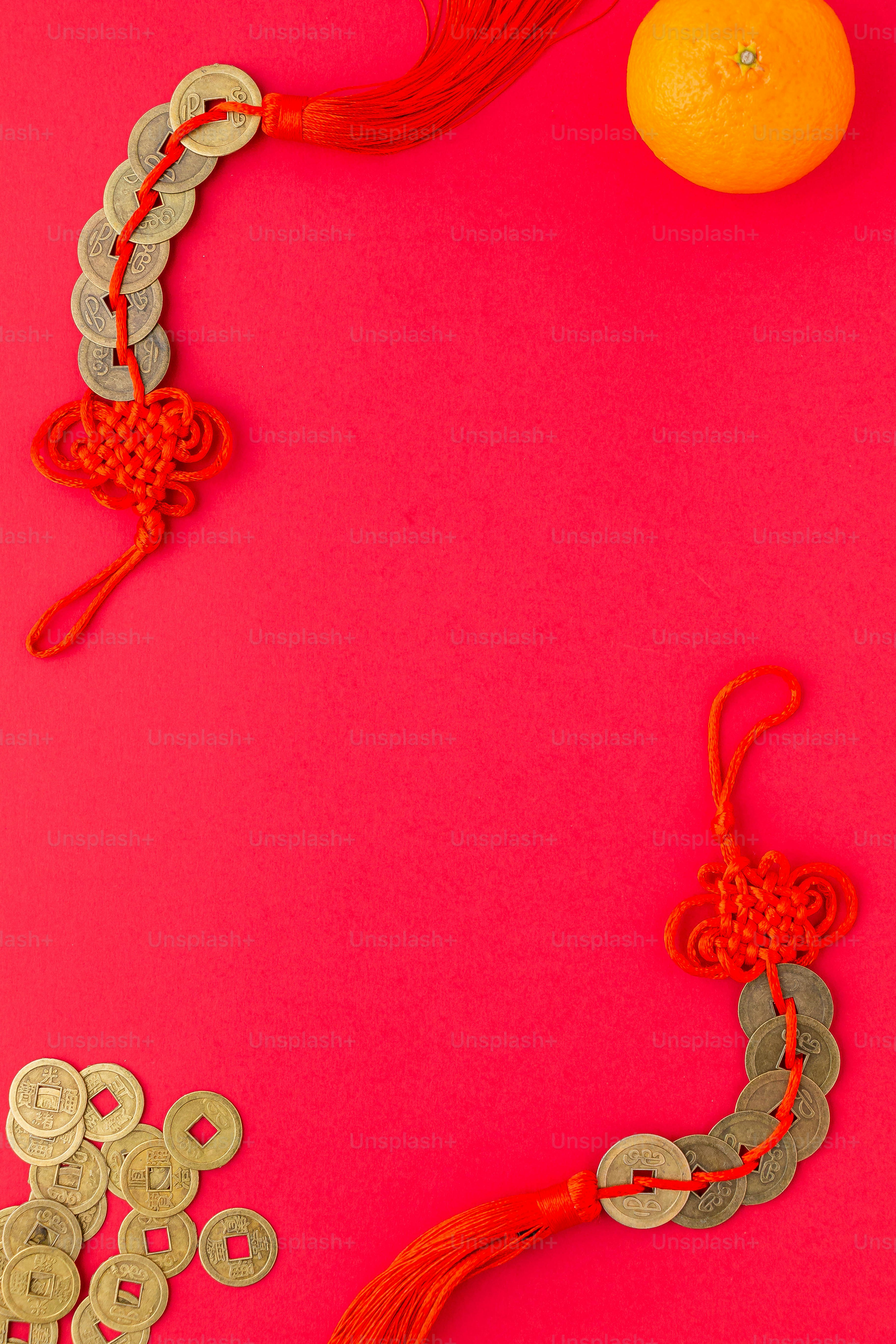 a red background with coins, a orange and a tassel