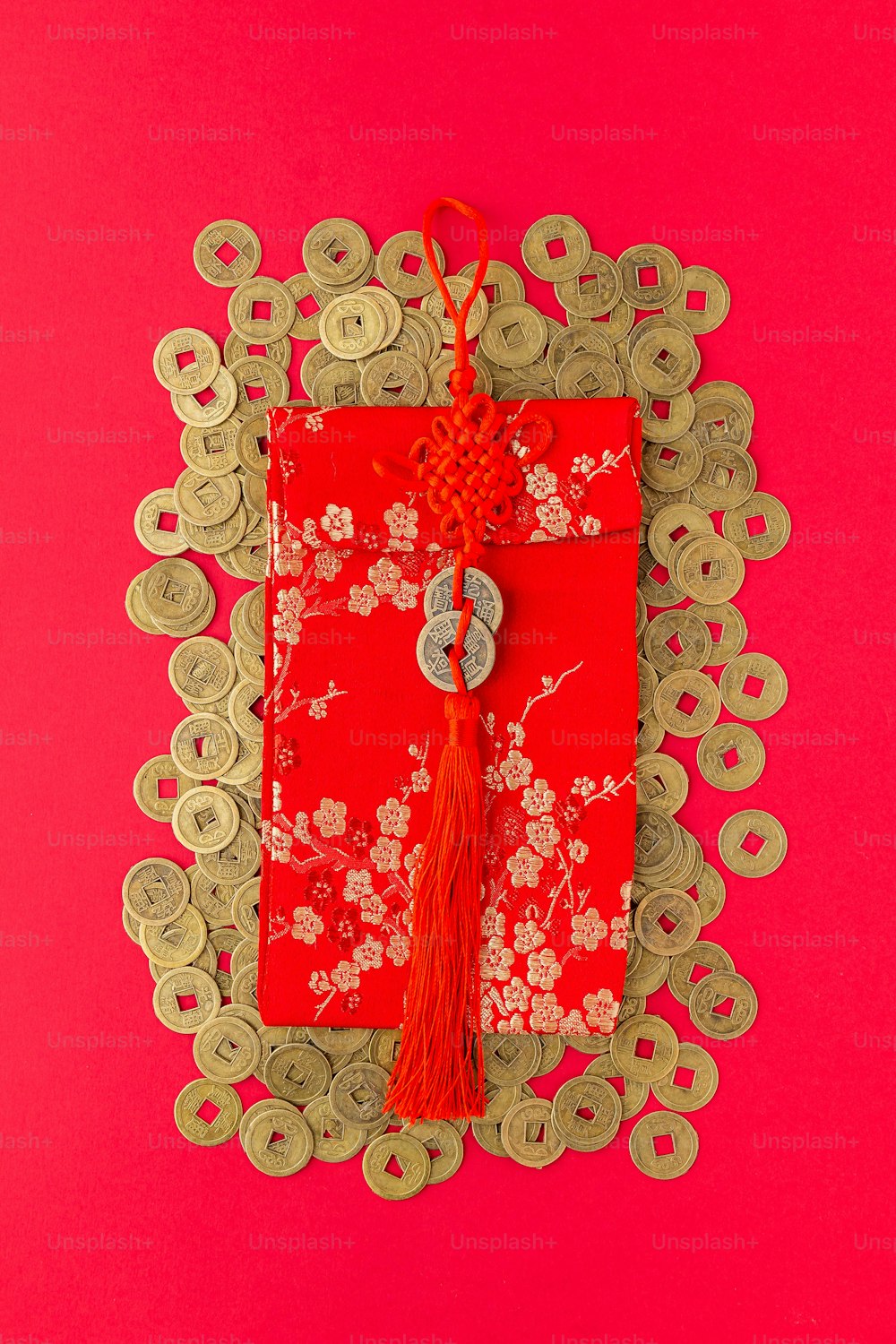 a red envelope with a red tassel on a pink background