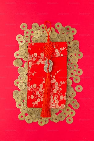 a red envelope with a red tassel on a pink background