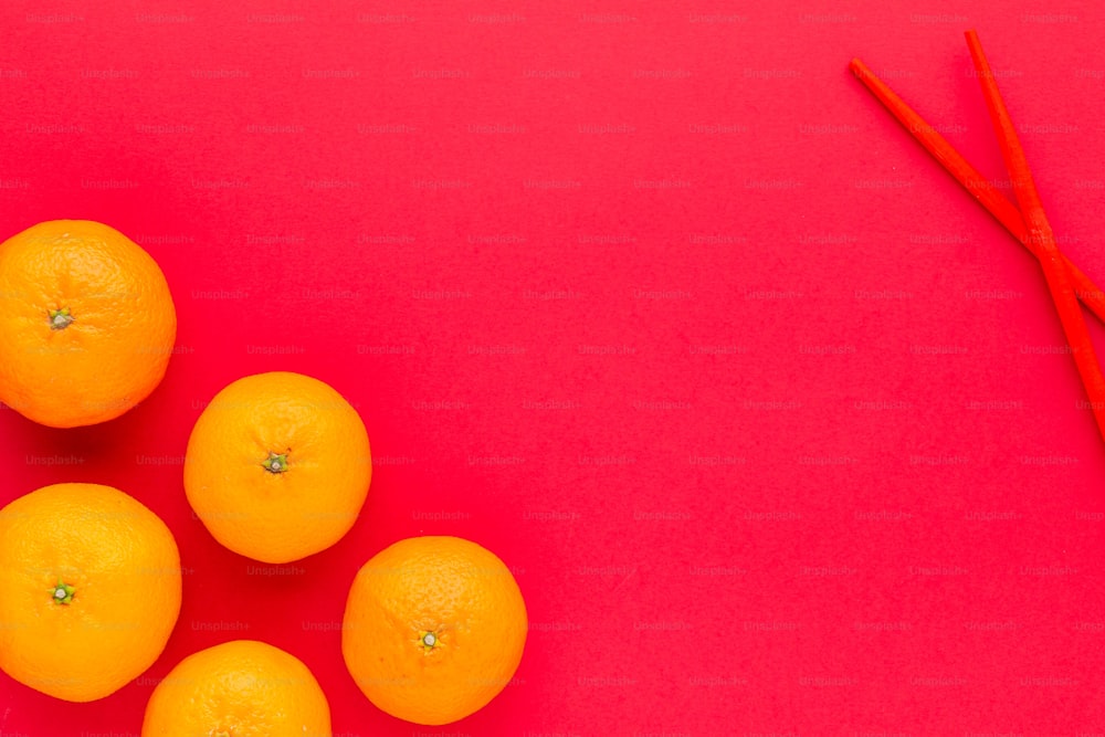um grupo de laranjas sentados em cima de uma mesa vermelha