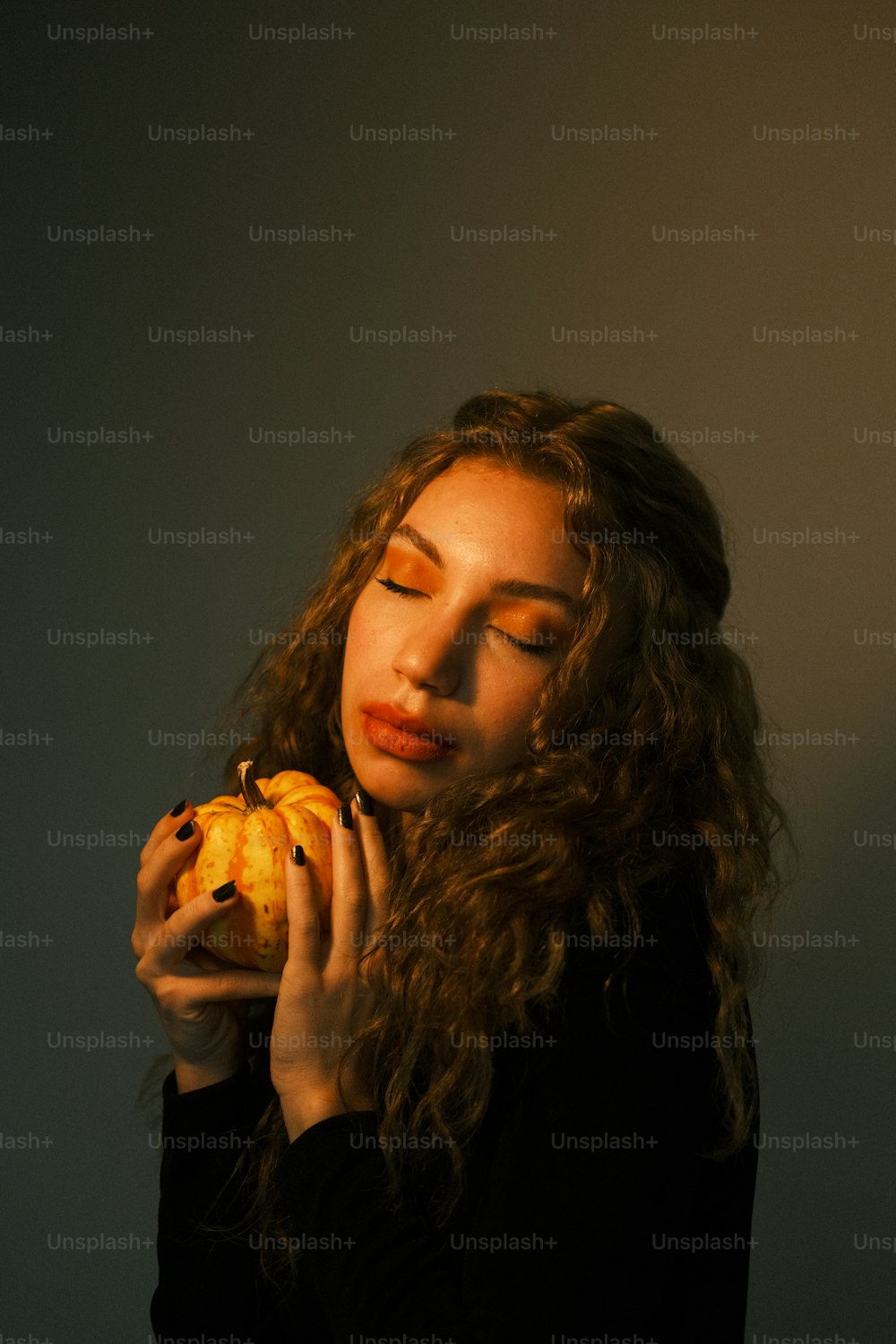 a woman holding a piece of fruit up to her face