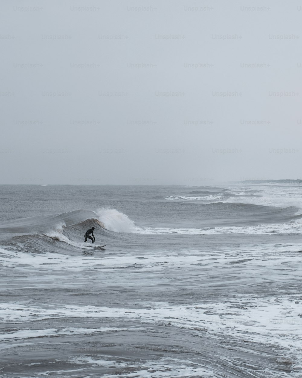 a man riding a wave on top of a surfboard