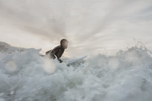 a man riding a wave on top of a surfboard