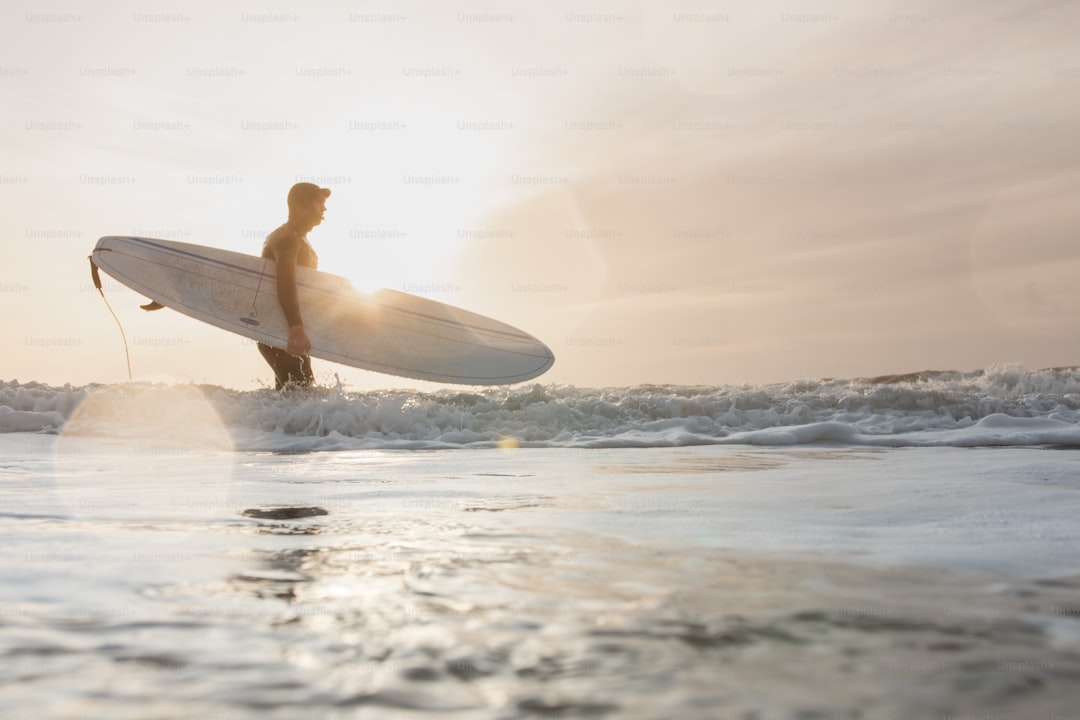 a man holding a surfboard while standing in the ocean