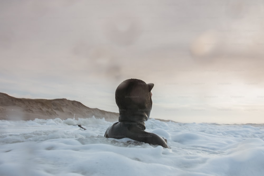 Eine Person, die mitten auf einem schneebedeckten Feld sitzt