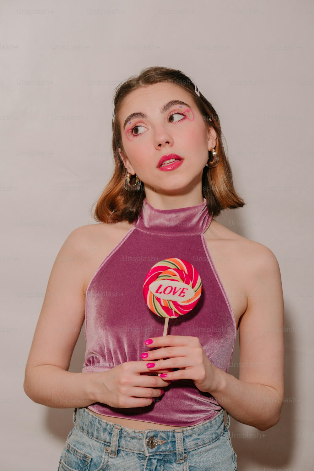 a woman holding a lollipop in her hands