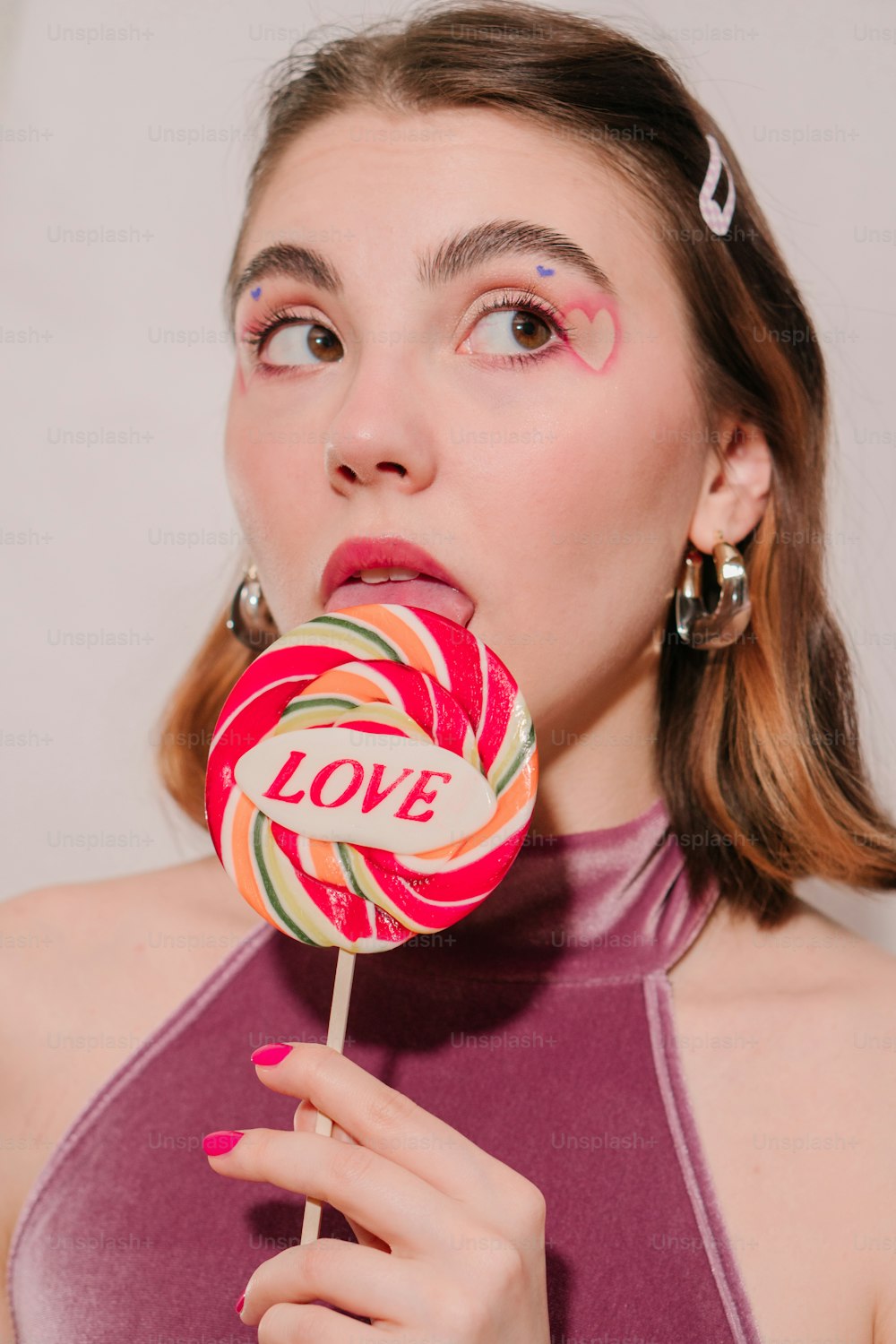 a woman holding a lollipop with the word love on it