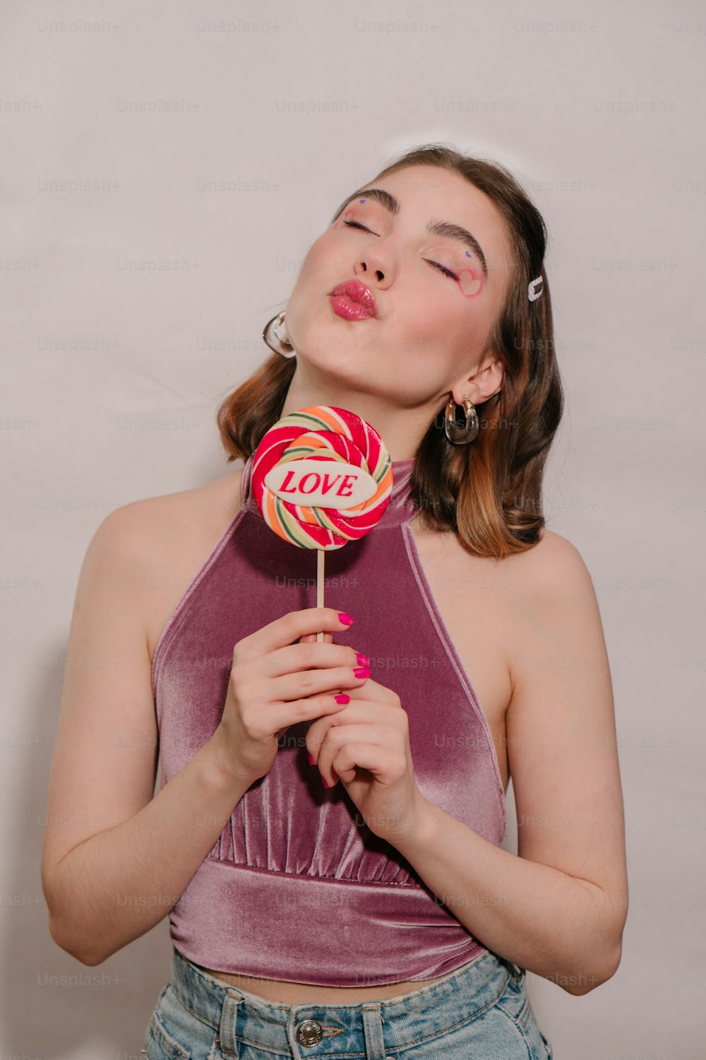 a woman holding a lollipop in her hands