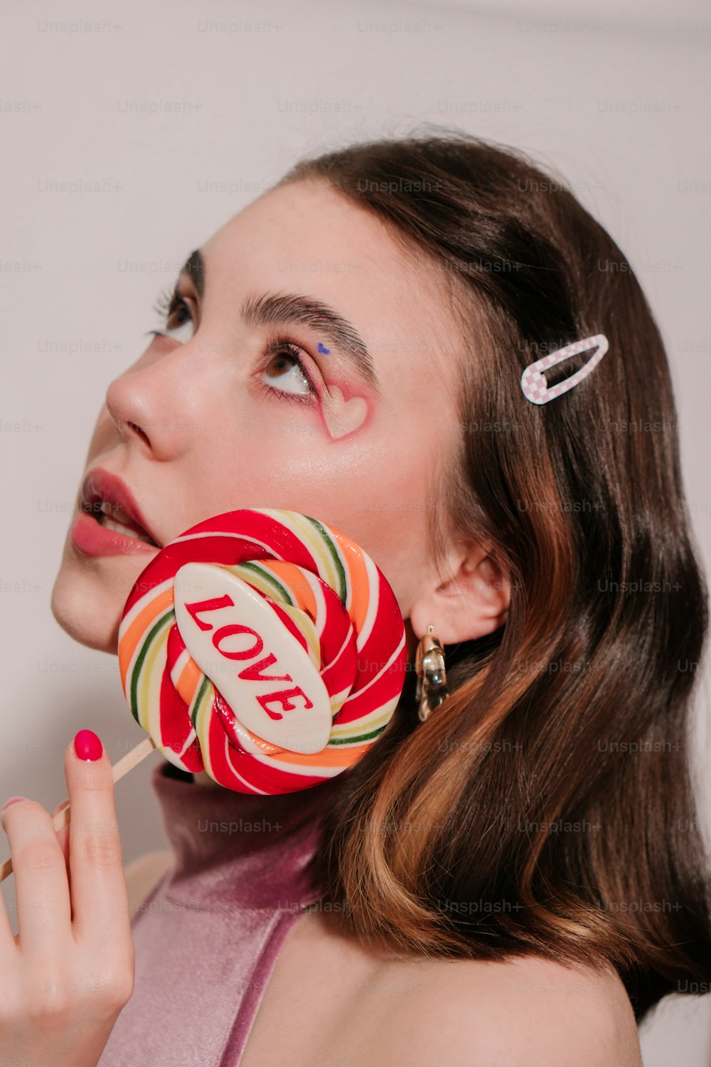 a woman holding a lollipop in her mouth
