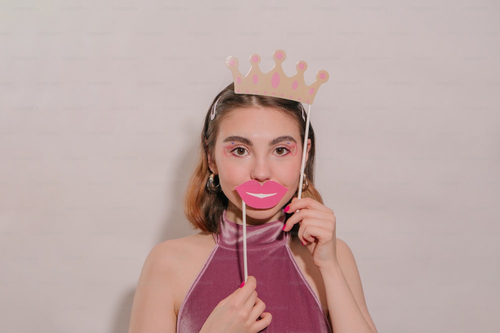 a woman wearing a crown holding a lollipop