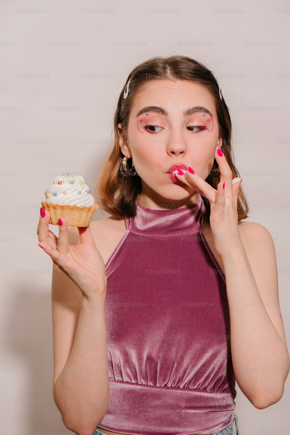 a woman holding a cupcake in her hands