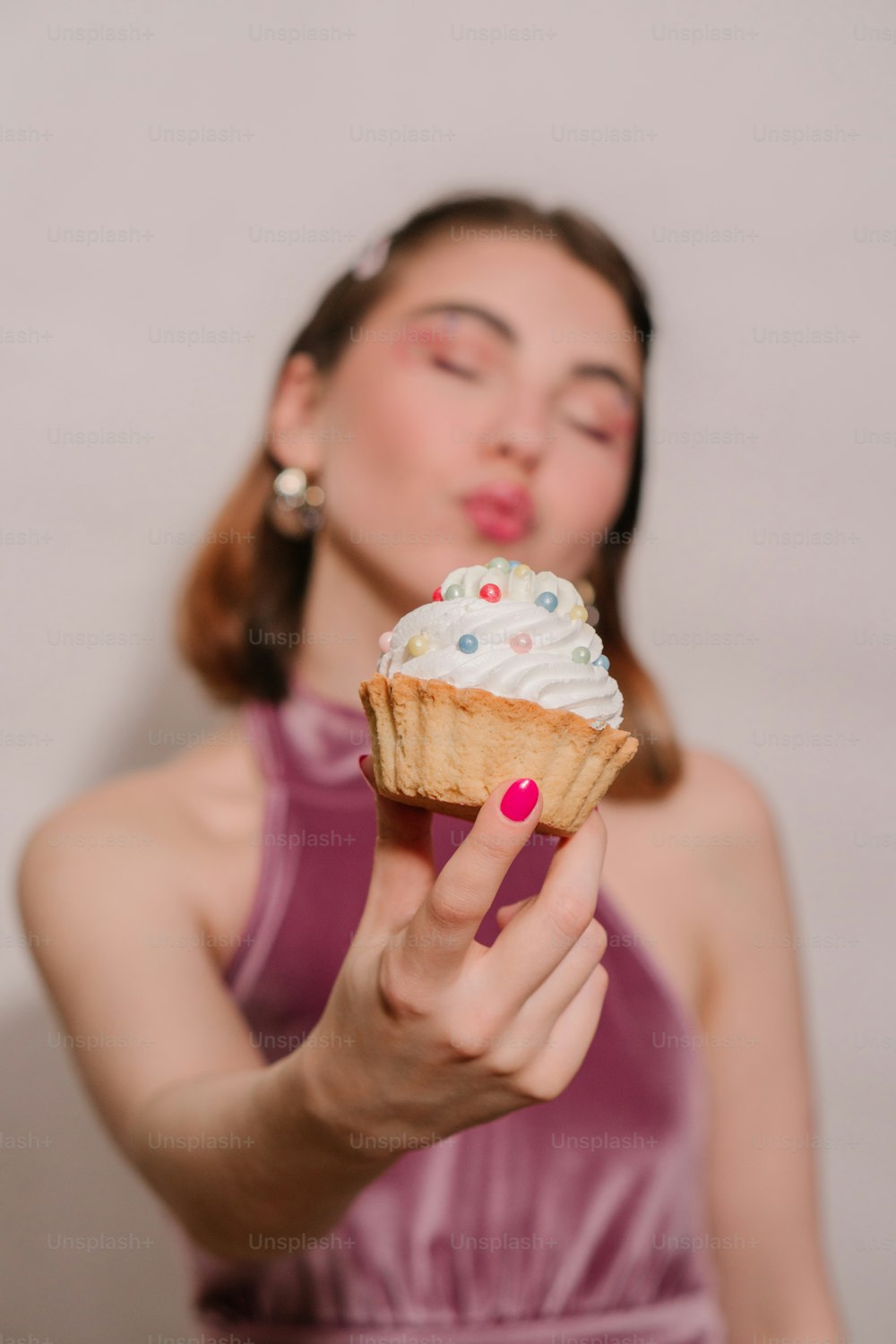 Una donna in un vestito viola che tiene un cono gelato