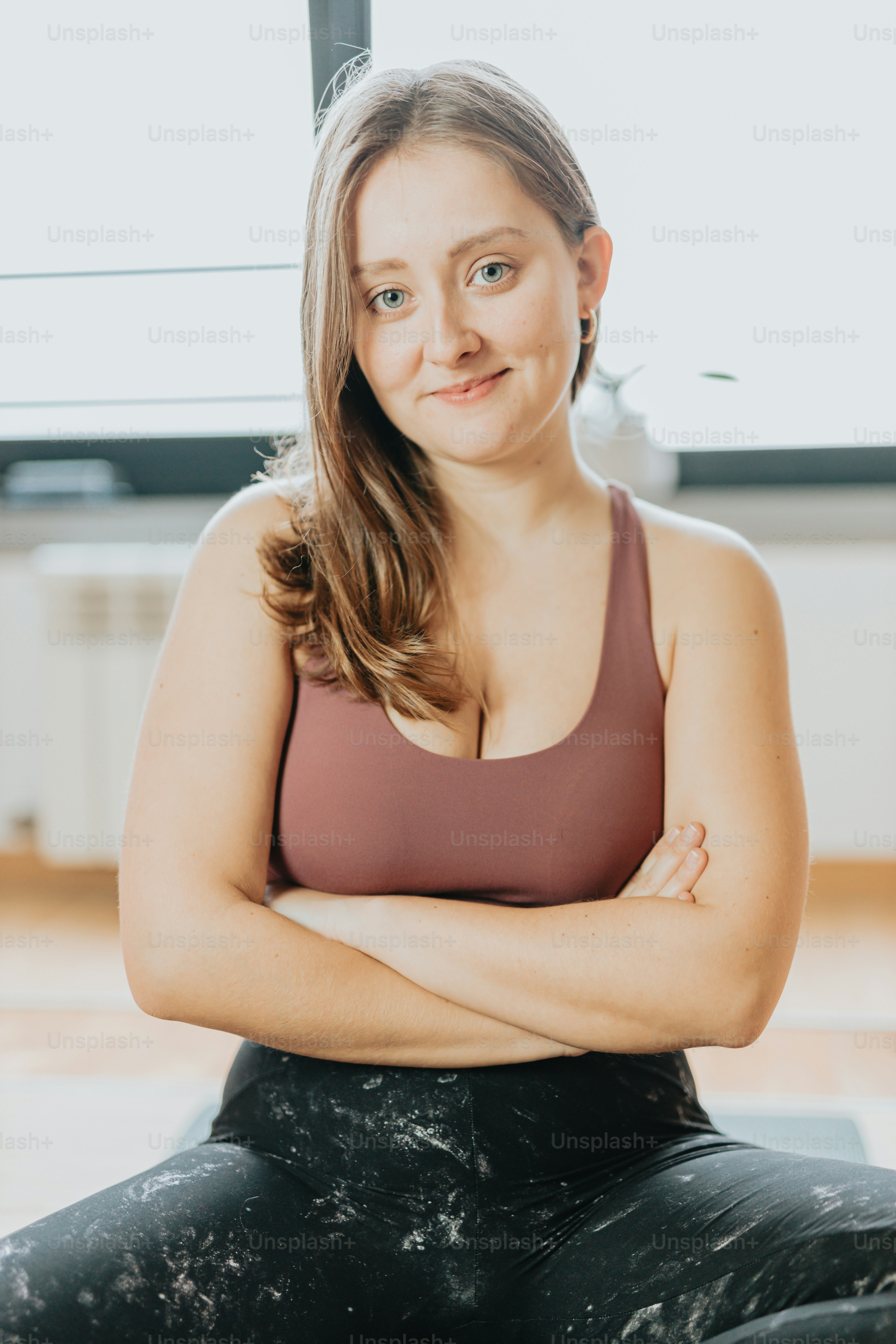 a woman sitting on the floor with her arms crossed