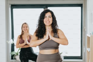 two women doing yoga in front of a window