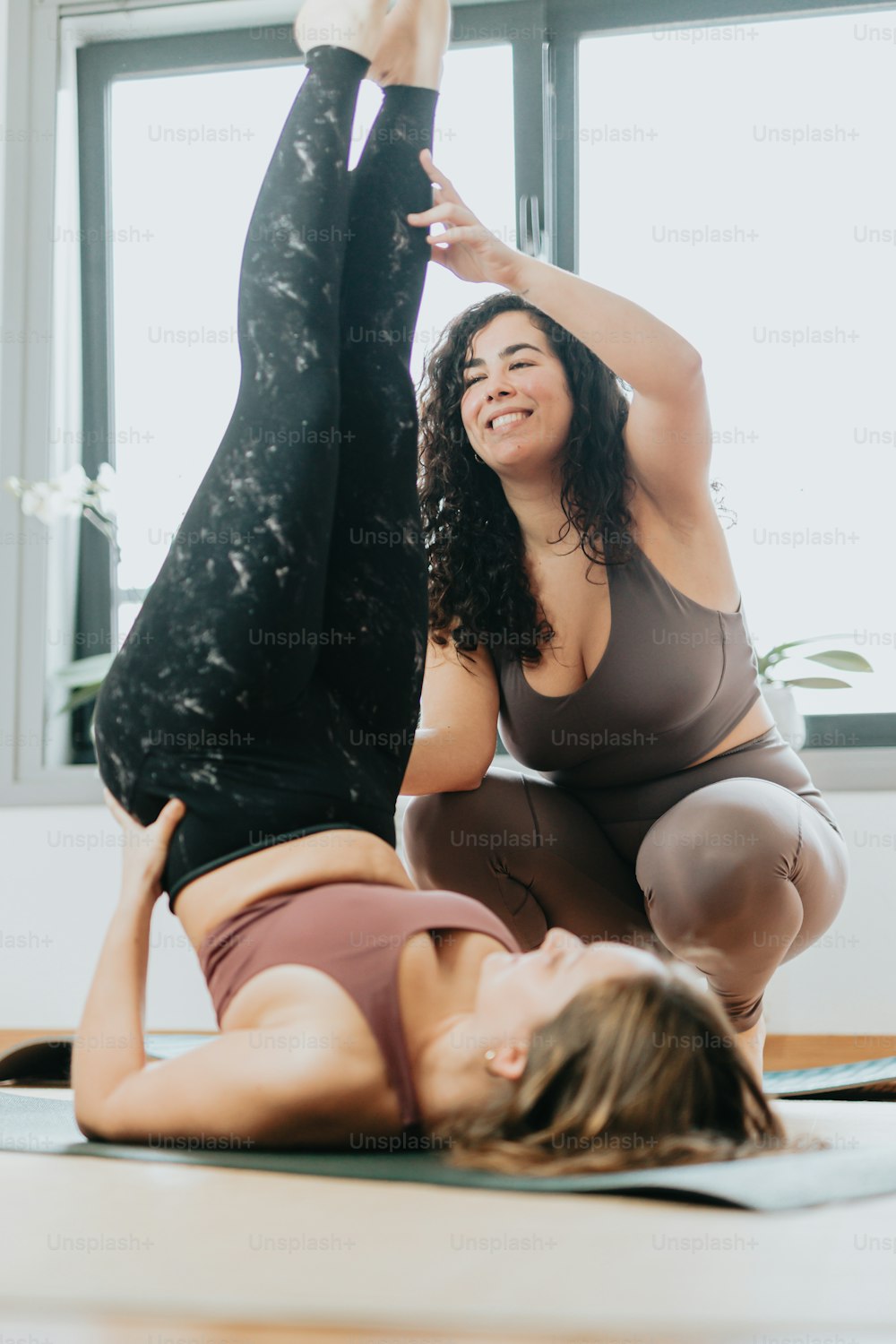 Deux femmes faisant des poses de yoga dans une pièce