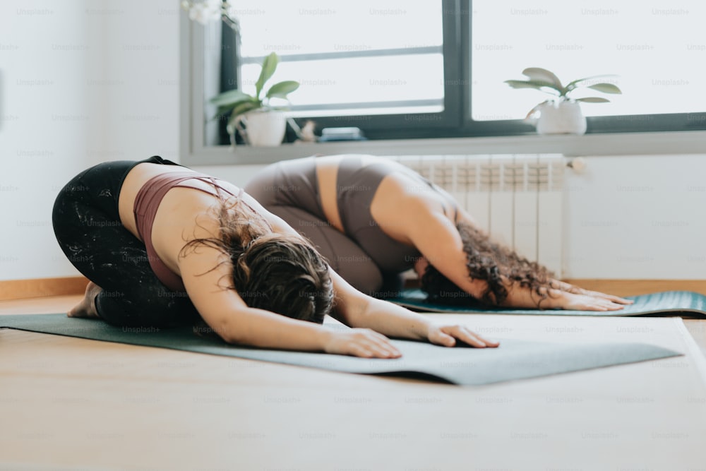 two women are doing yoga in a room