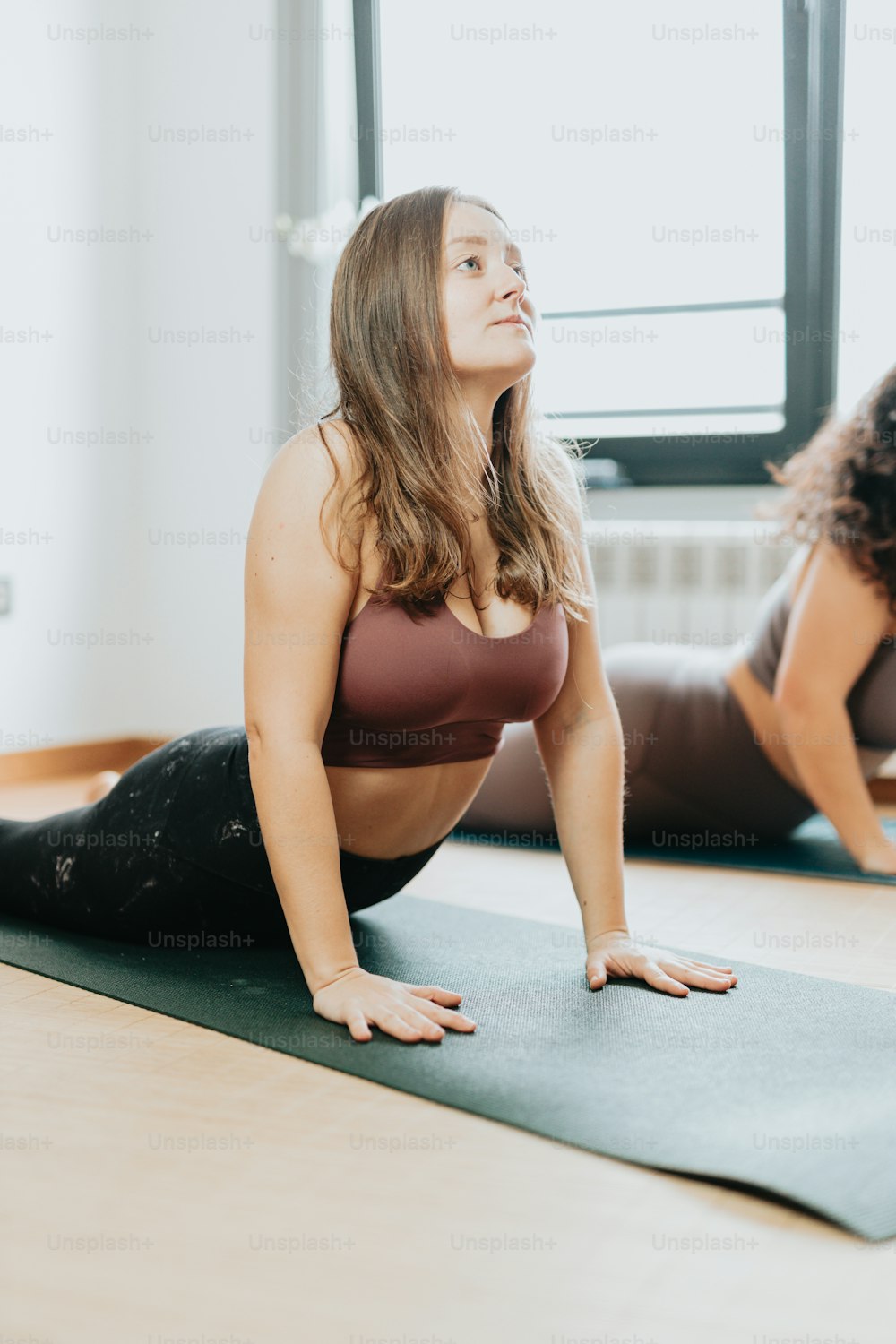 two women are doing yoga on a mat