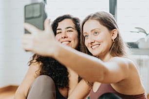 two women taking a picture with their cell phone