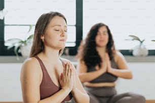 a woman sitting in a yoga position with her eyes closed