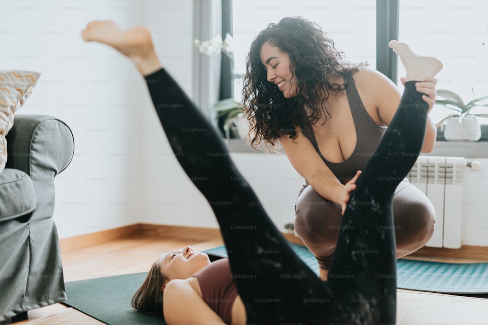 two women doing yoga exercises in a living room