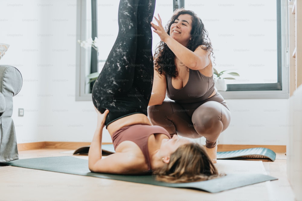two women doing yoga poses in a room