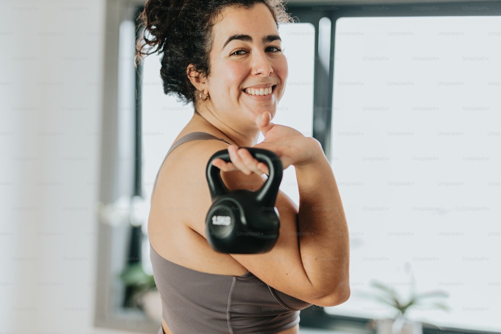 a woman is smiling while holding a kettle