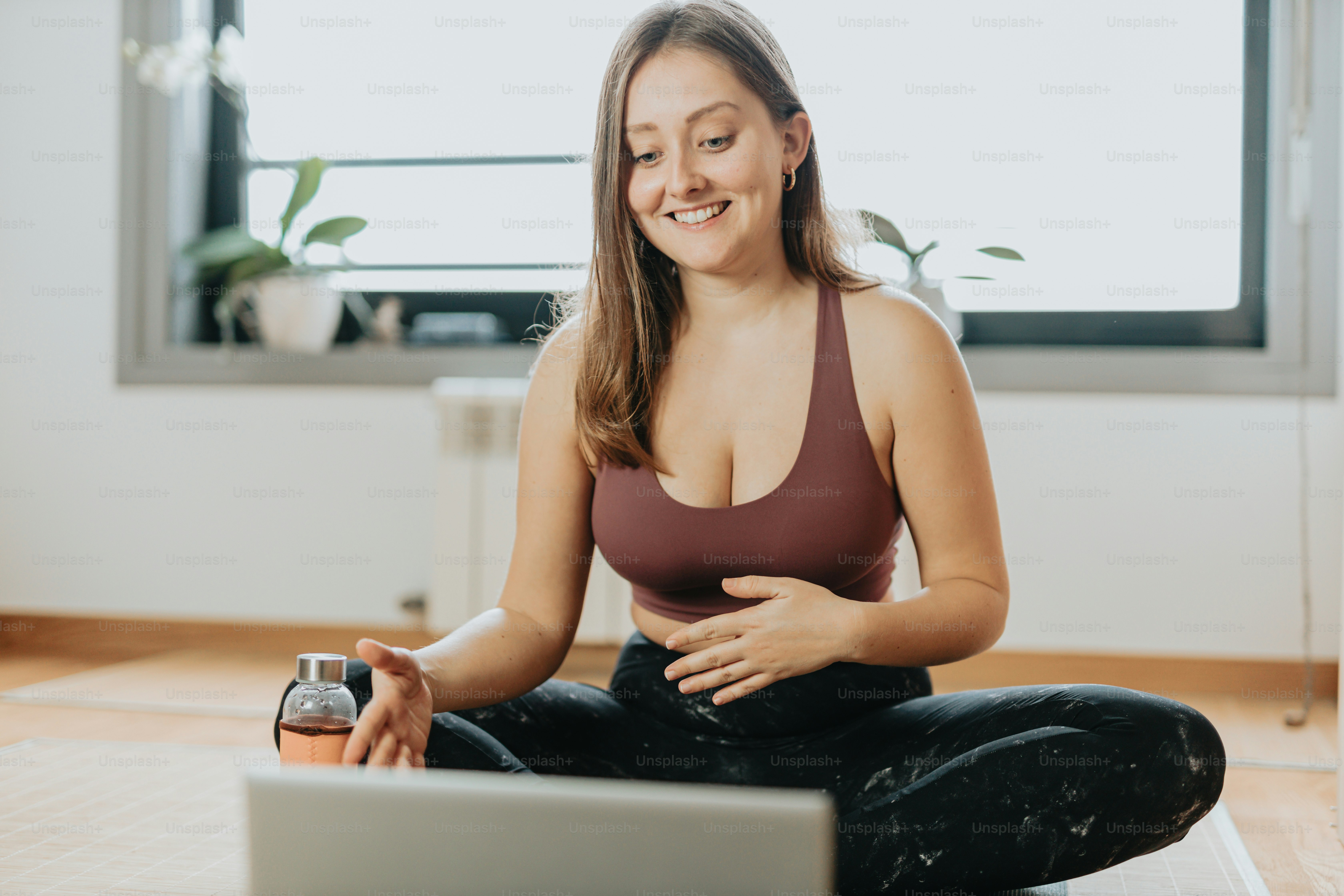a woman sitting on the floor in front of a laptop