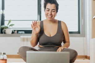 a woman sitting on the floor in front of a laptop