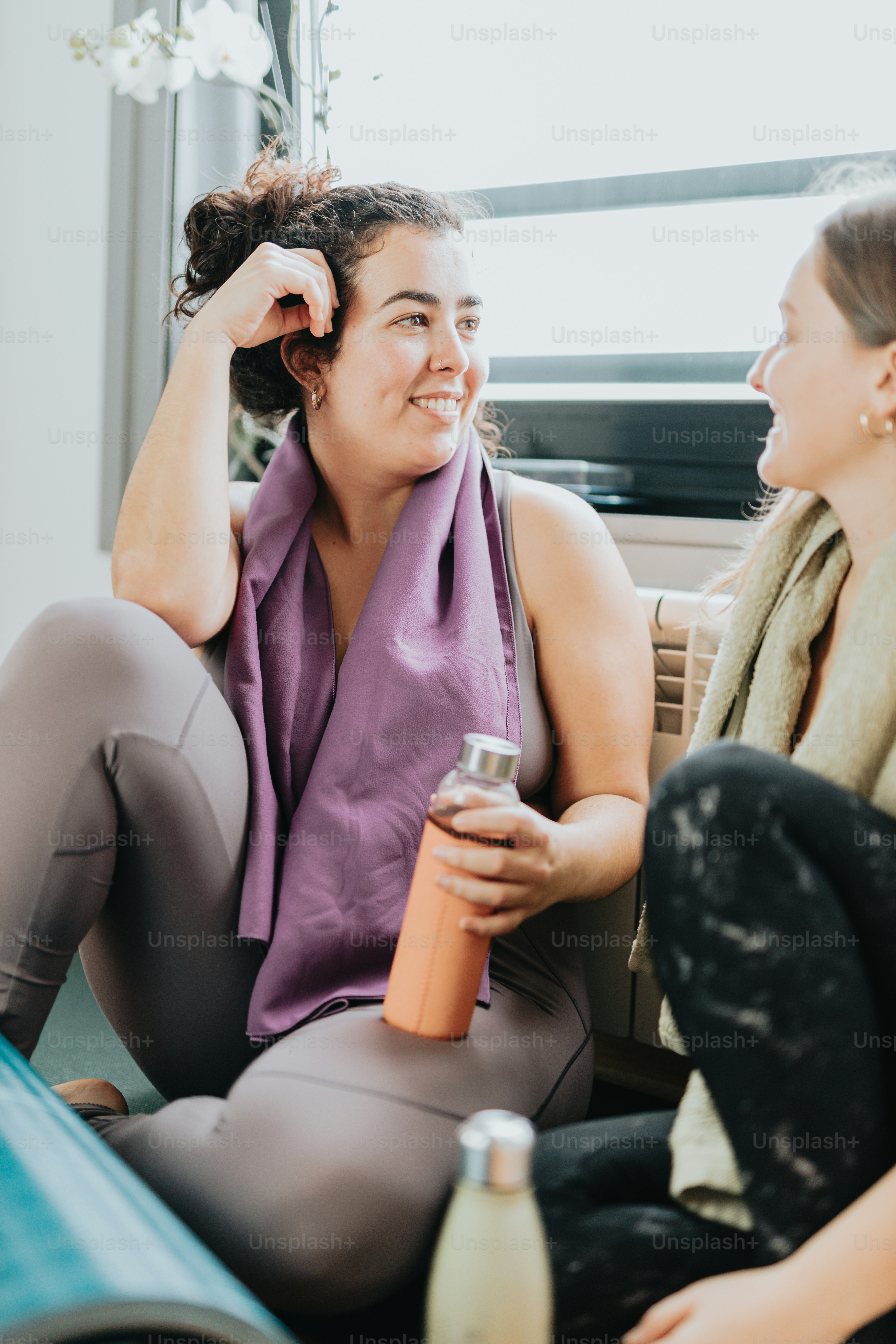 two women sitting on a couch talking to each other