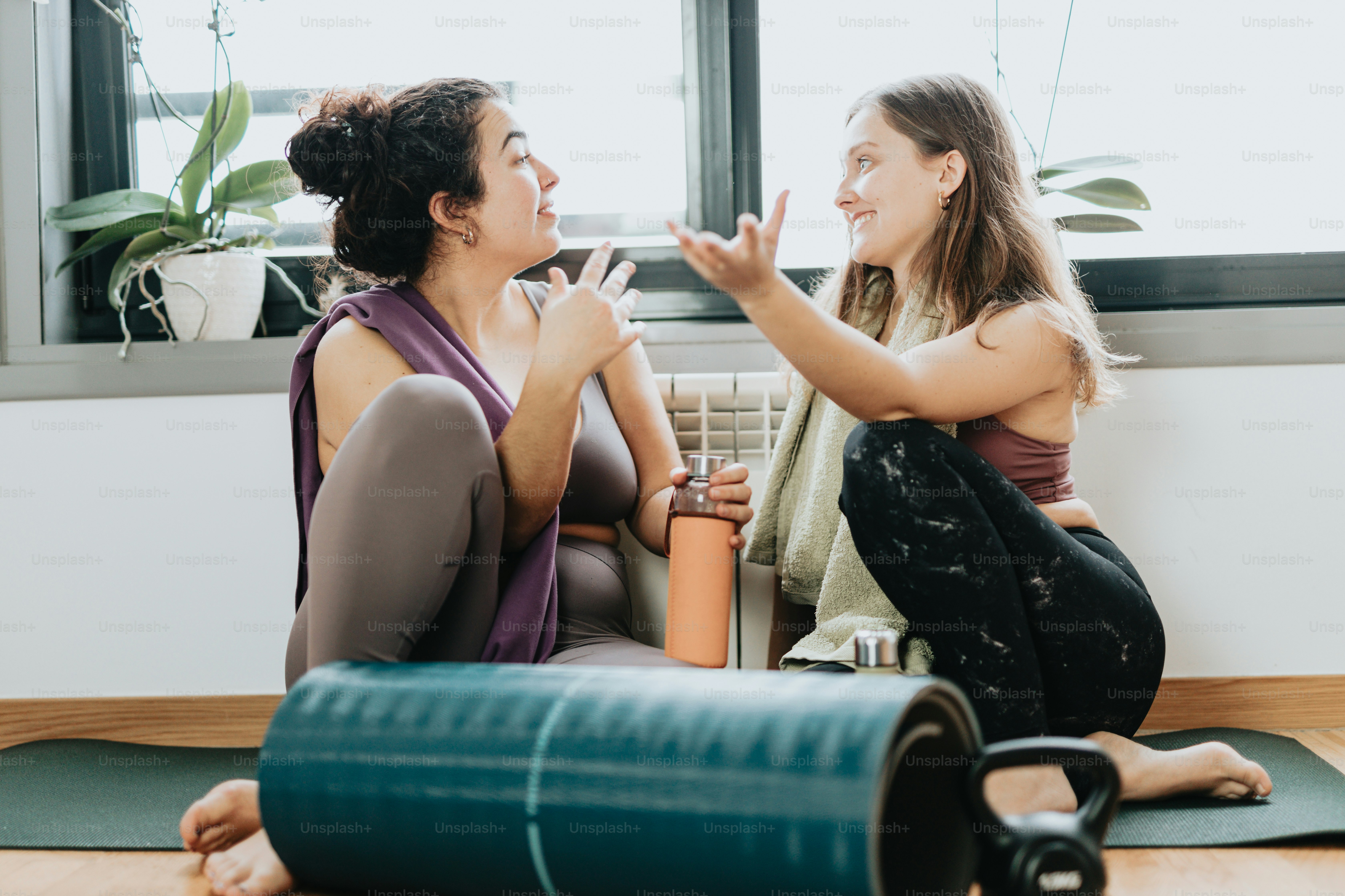 A woman sitting on a yoga mat with a laptop in front of her photo ...