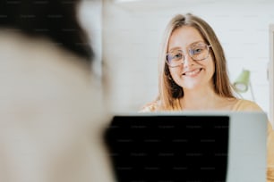 uma mulher que usa óculos olhando para uma tela de computador