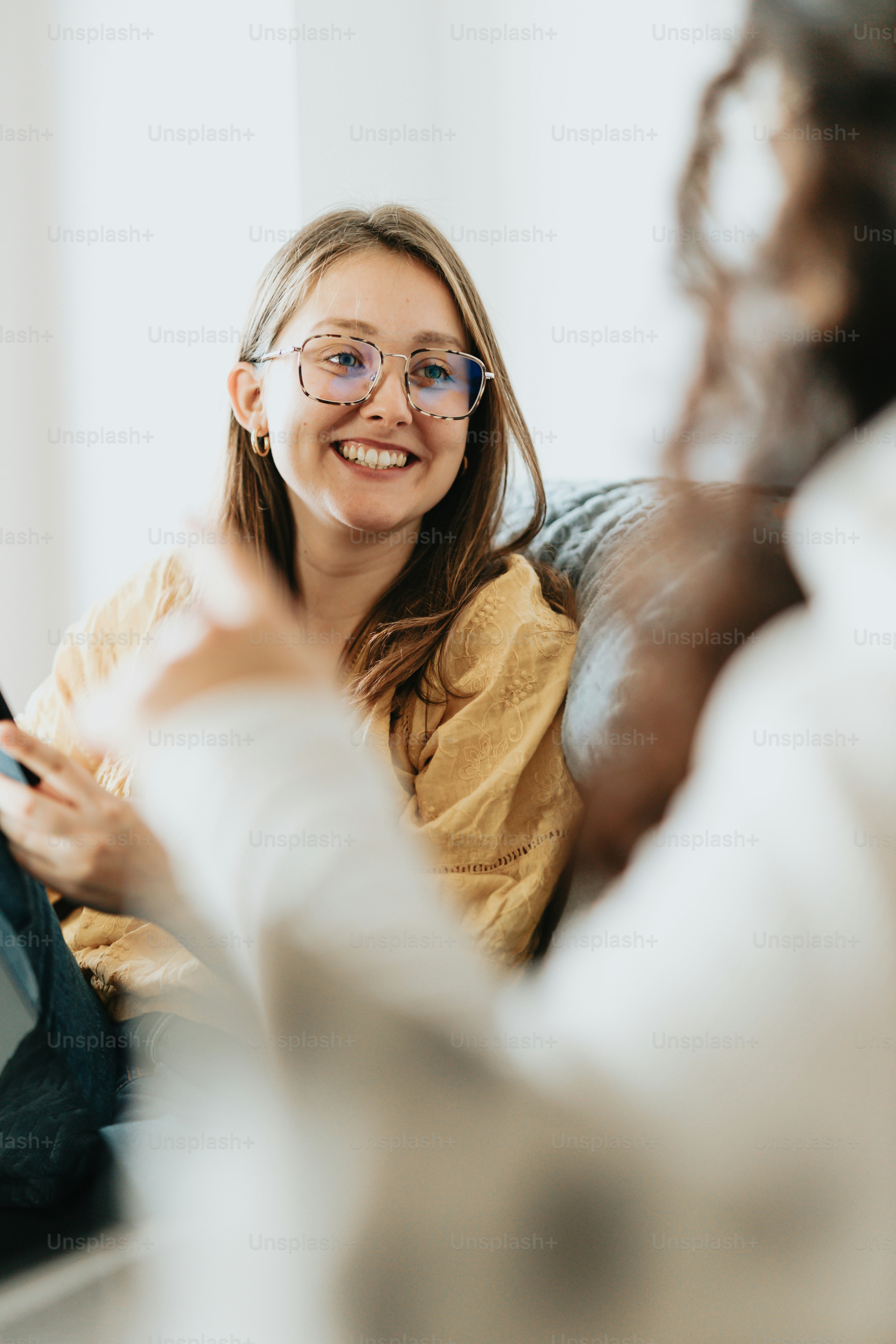a woman wearing glasses sitting on a couch