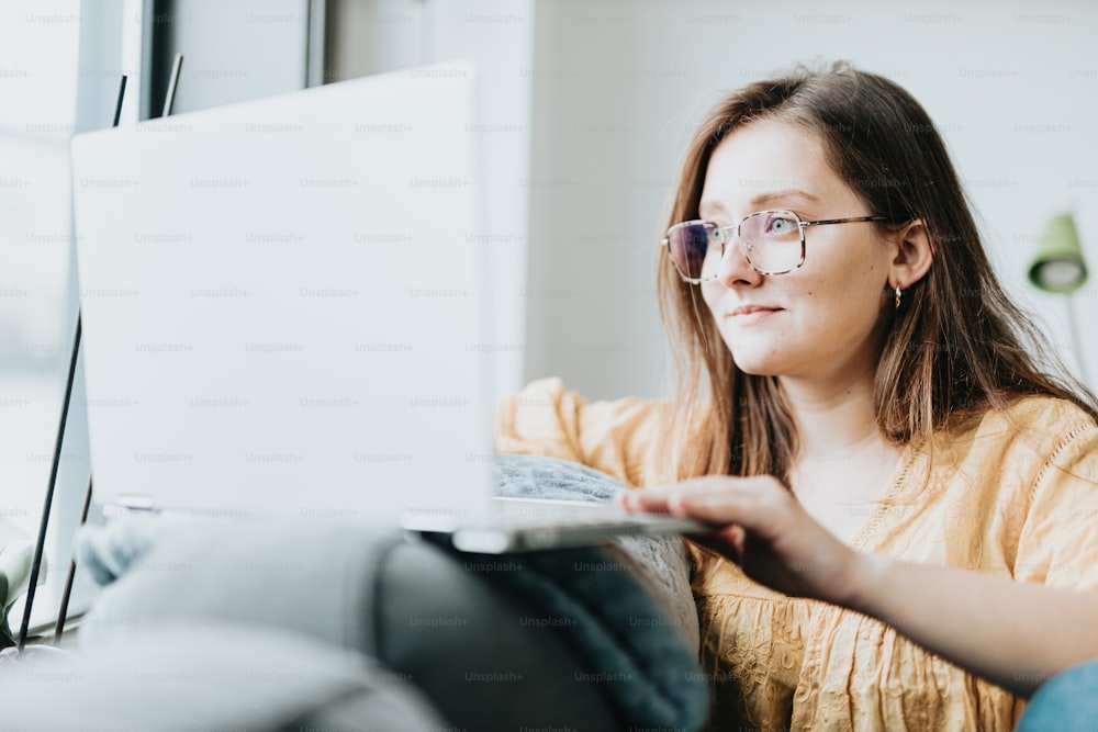 Eine Frau mit Brille schaut auf einen Laptop