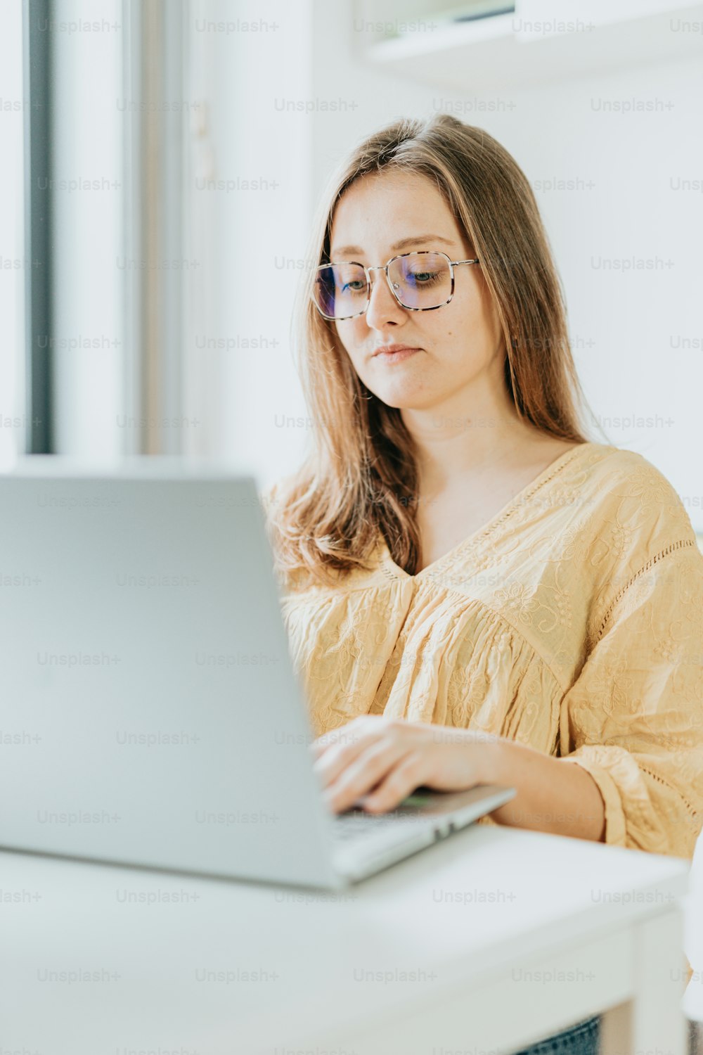 Eine Frau sitzt an einem Schreibtisch mit einem Laptop