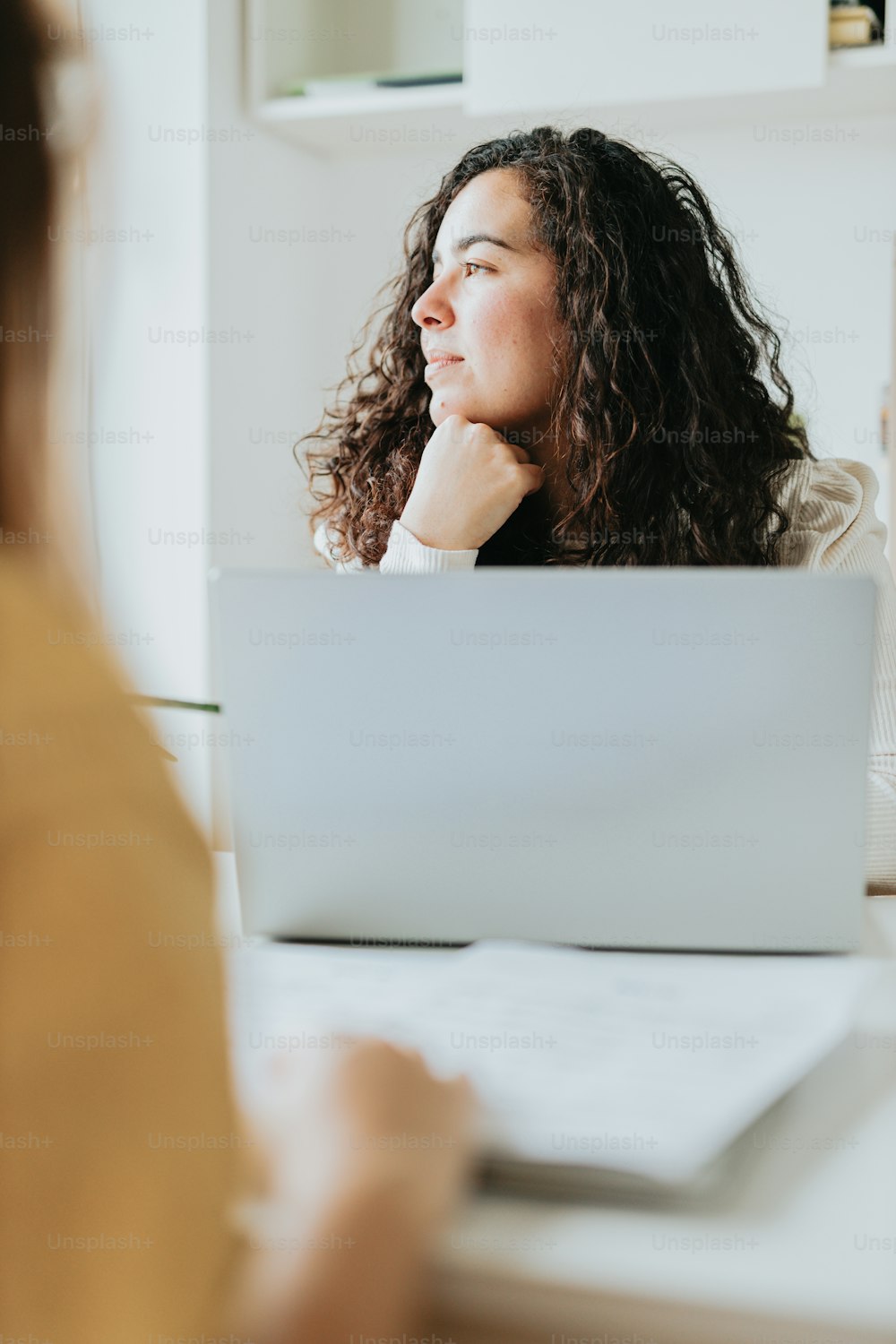 a woman sitting in front of a laptop computer