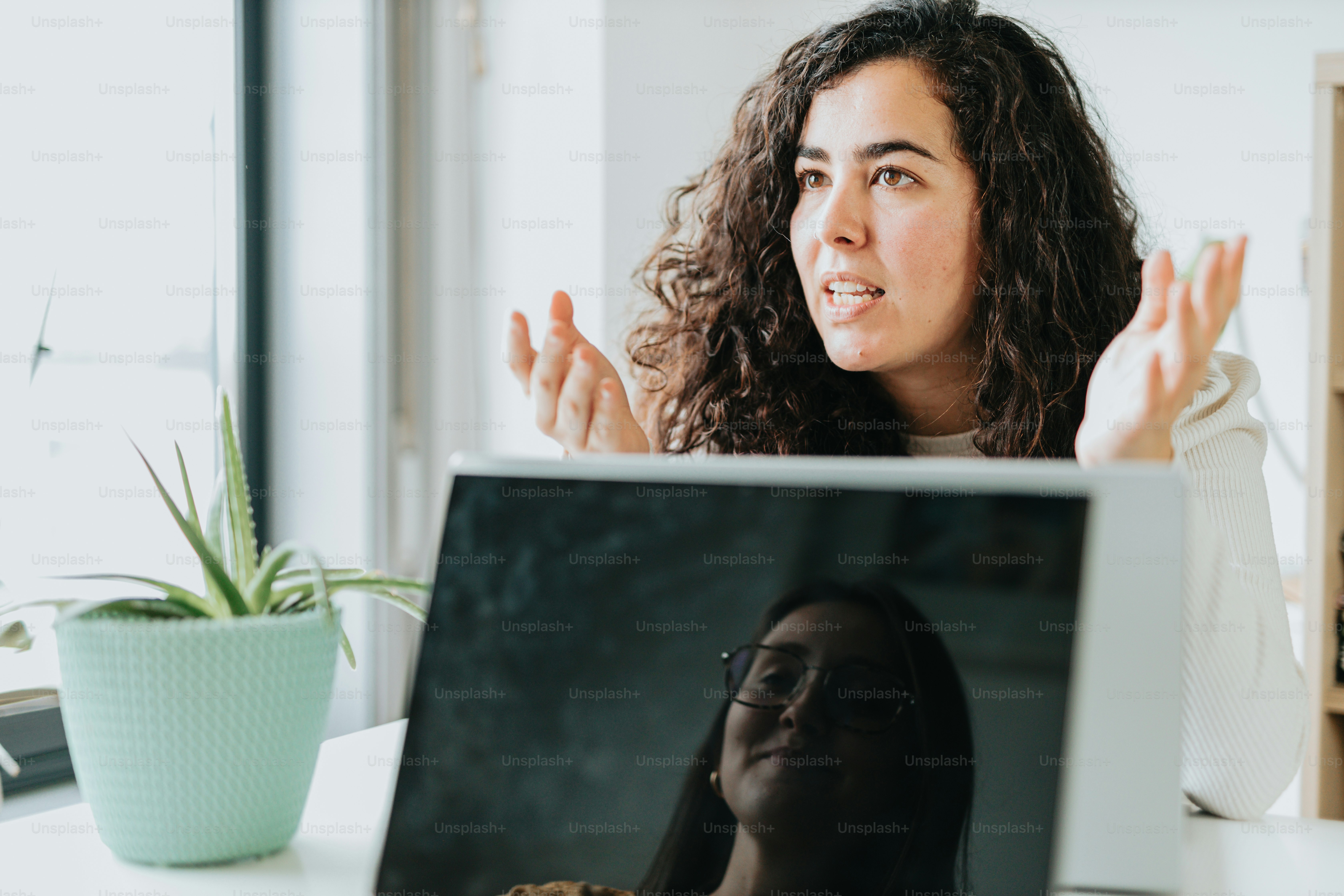 a woman sitting in front of a laptop computer