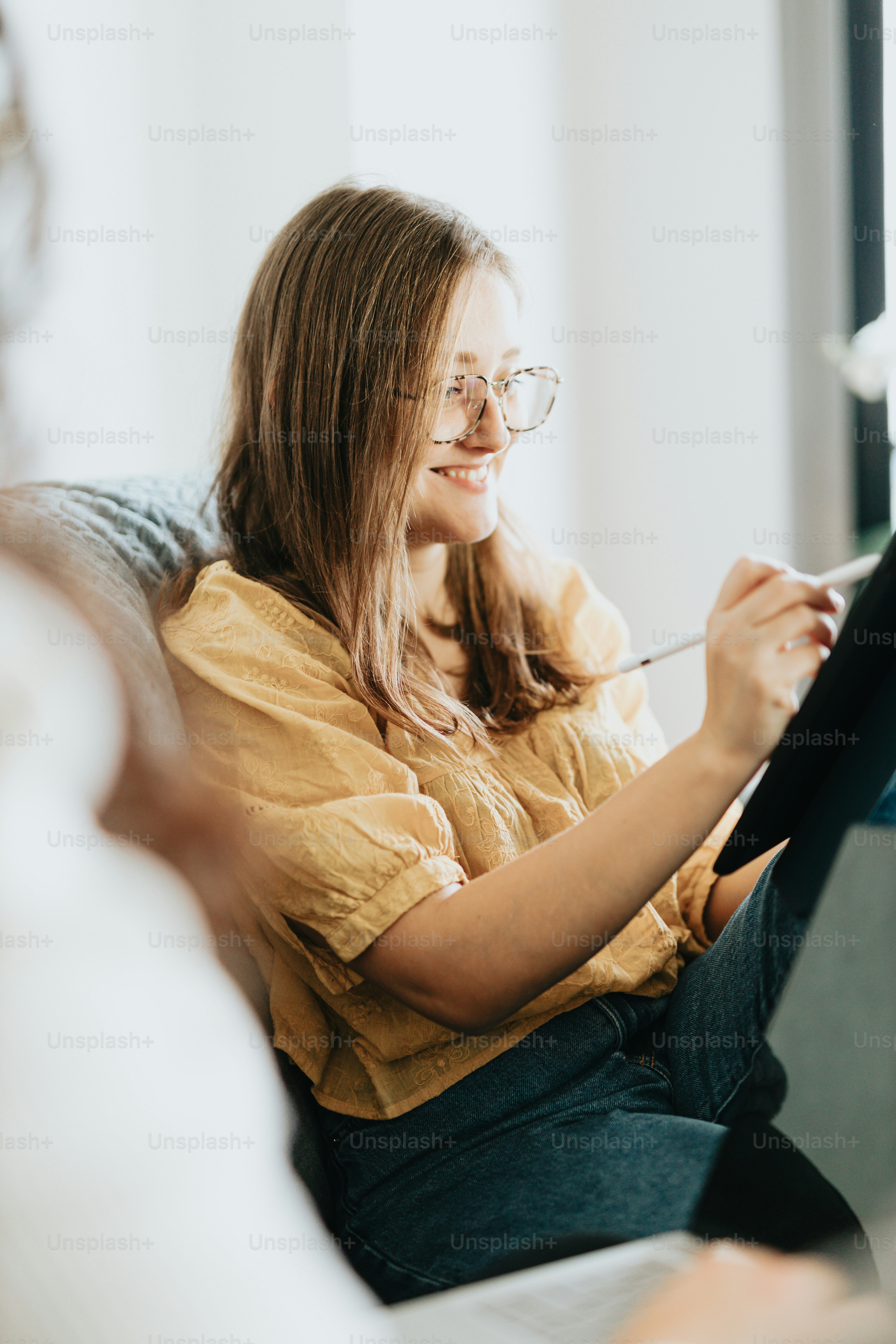 a woman sitting on a couch using a tablet