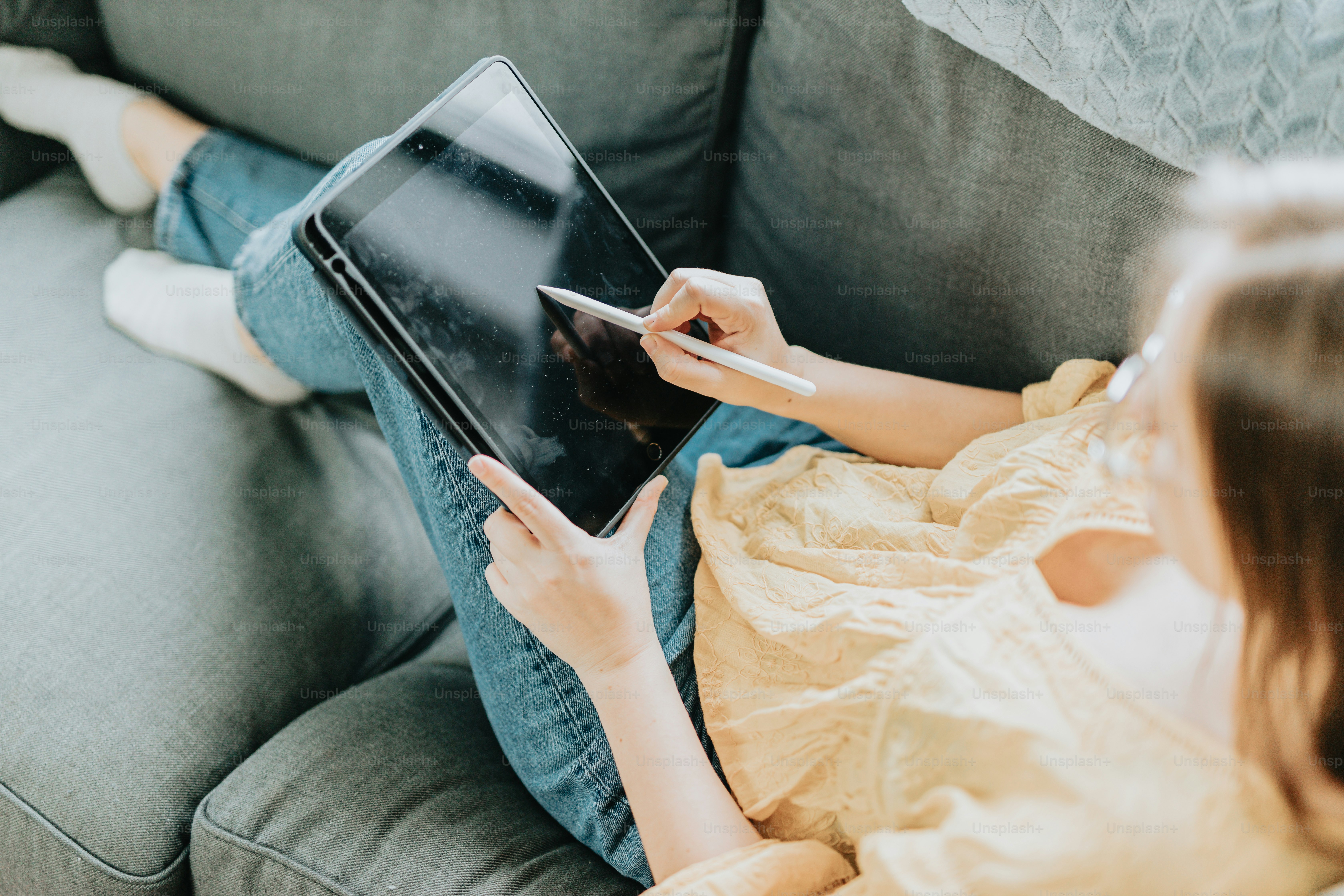 a woman sitting on a couch using a laptop computer