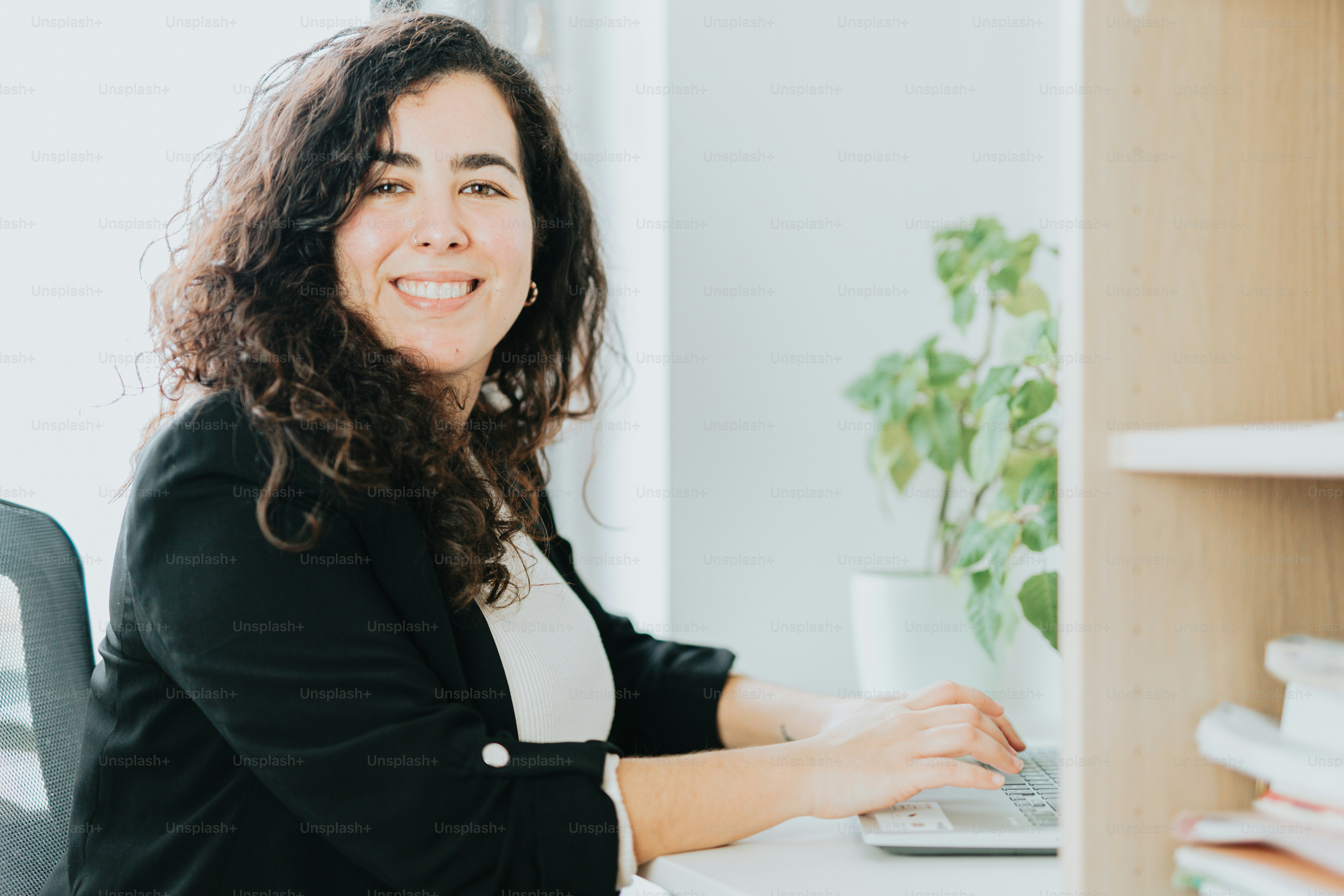 a woman sitting at a desk with a laptop
