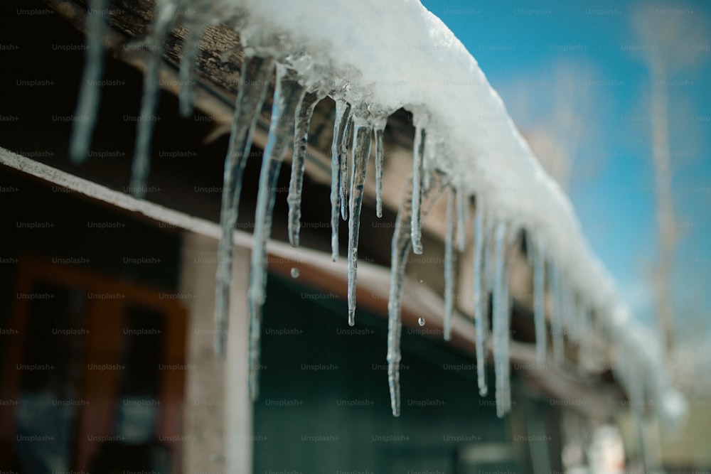 icicles are hanging from the roof of a house