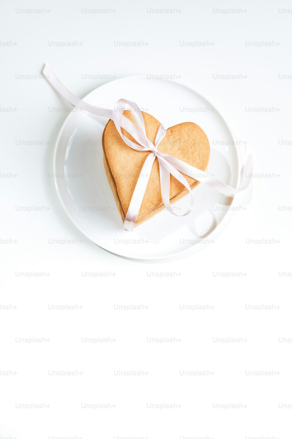 um biscoito em forma de coração em uma placa branca
