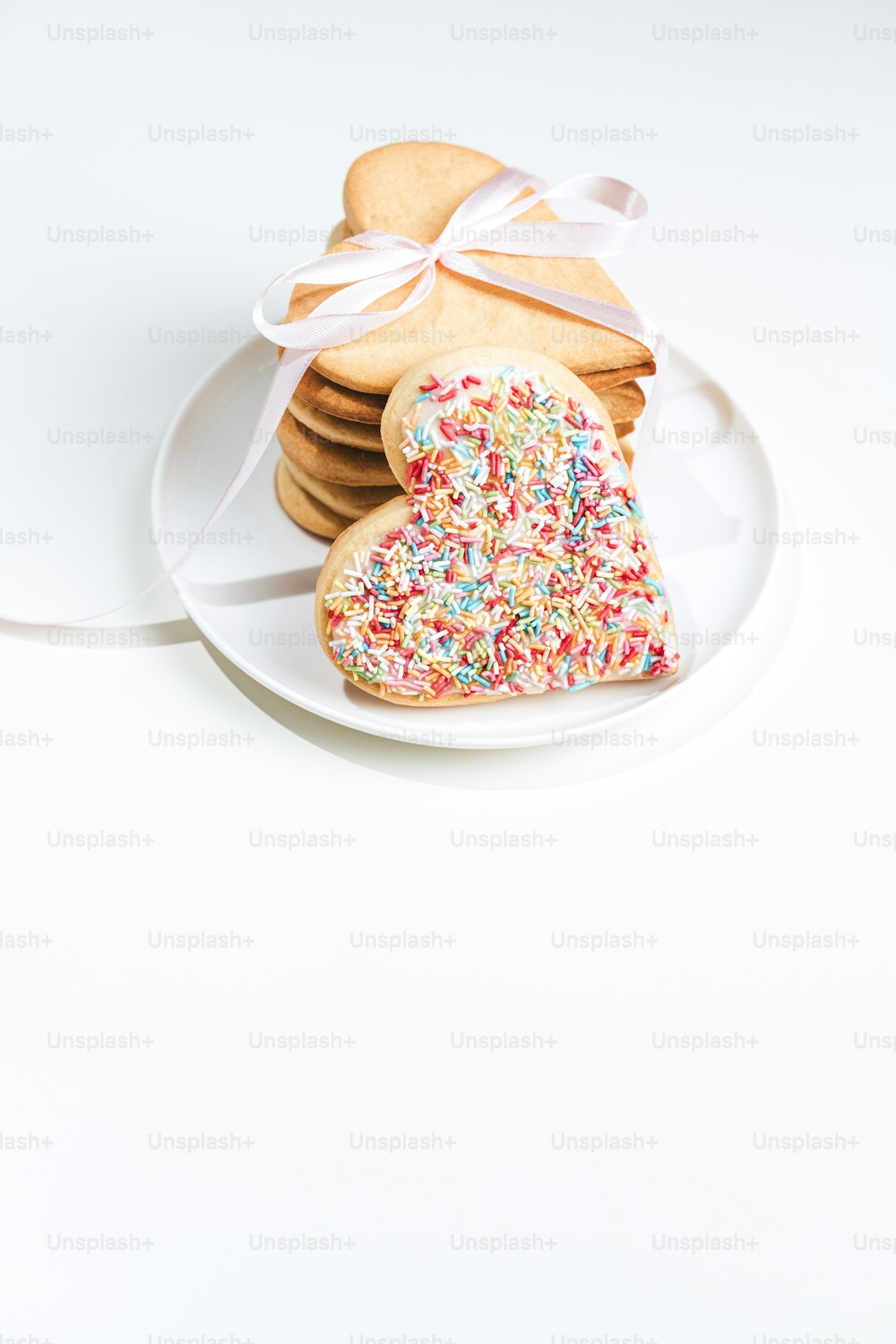 a white plate topped with cookies covered in sprinkles