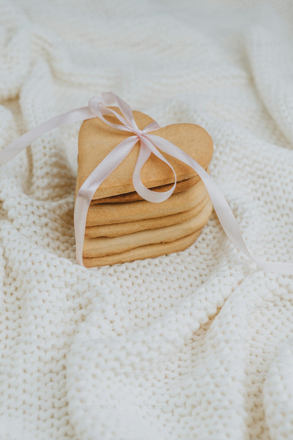 a stack of heart shaped cookies on a blanket