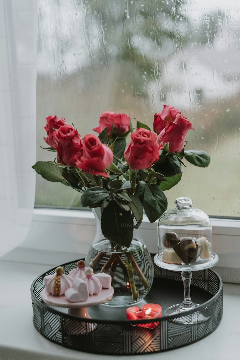 un vaso di rose seduto sopra un vassoio