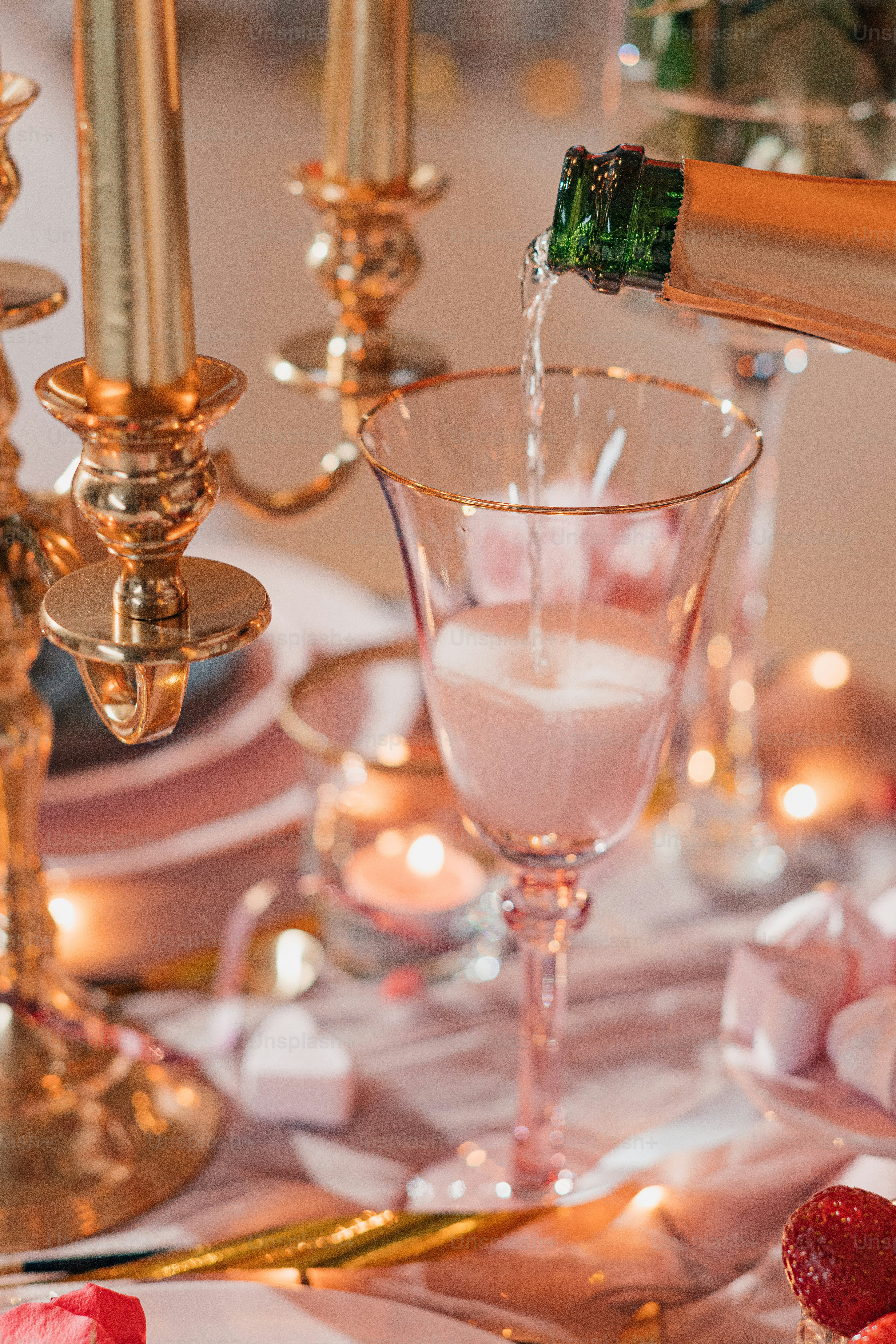 a table topped with a wine glass filled with liquid
