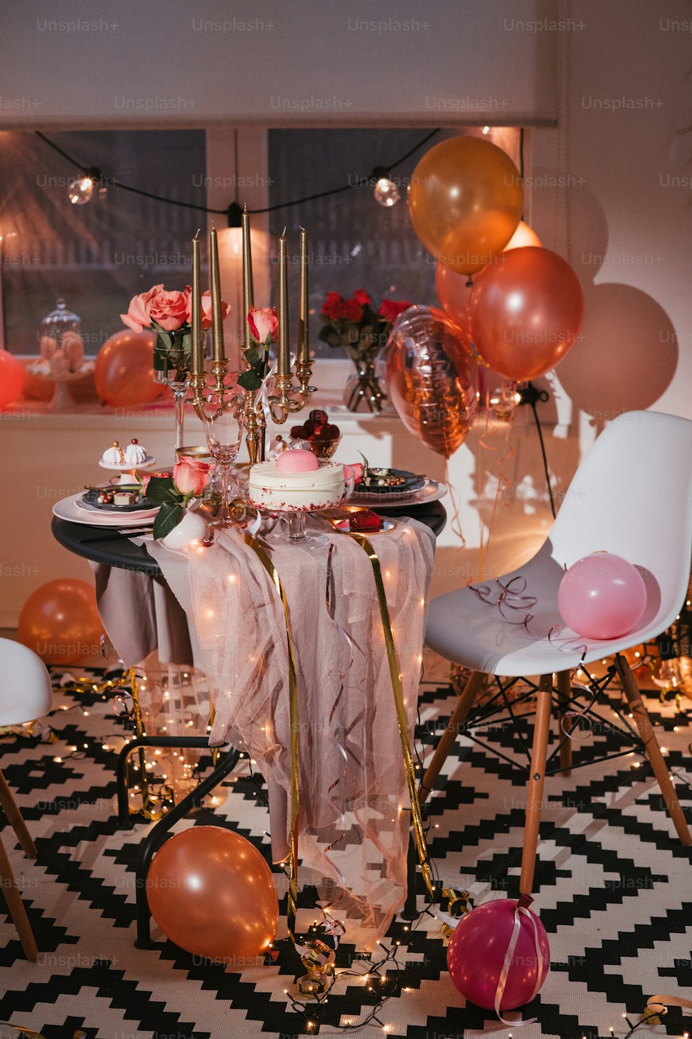 a table with a cake and balloons on it