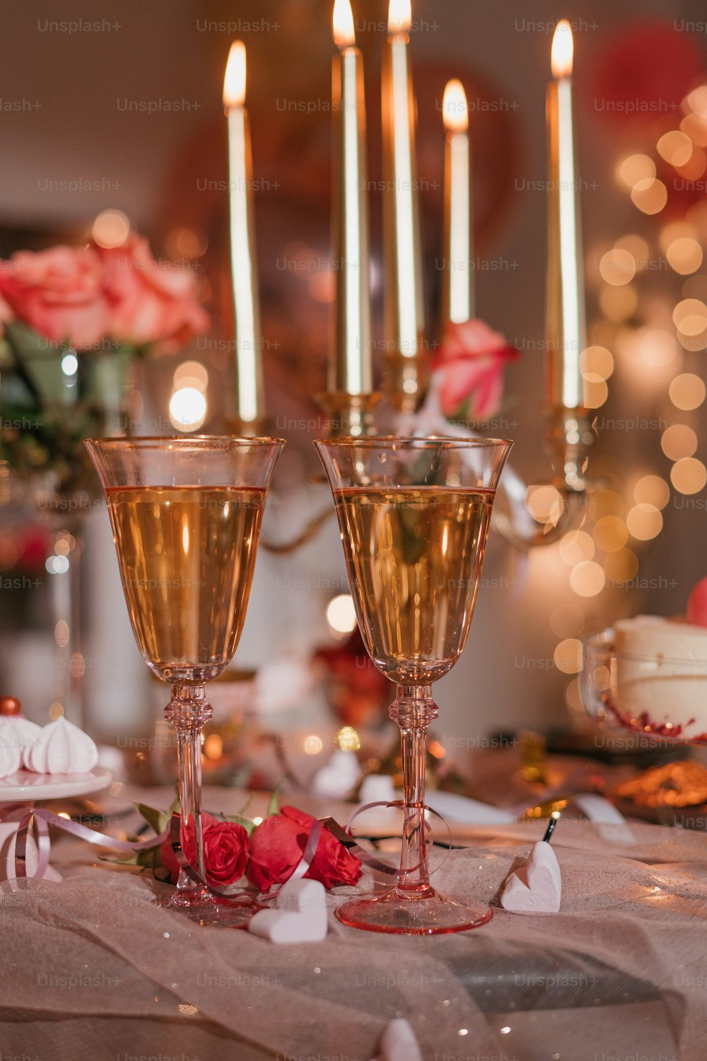 uma mesa coberta com duas taças de vinho cheias de champanhe