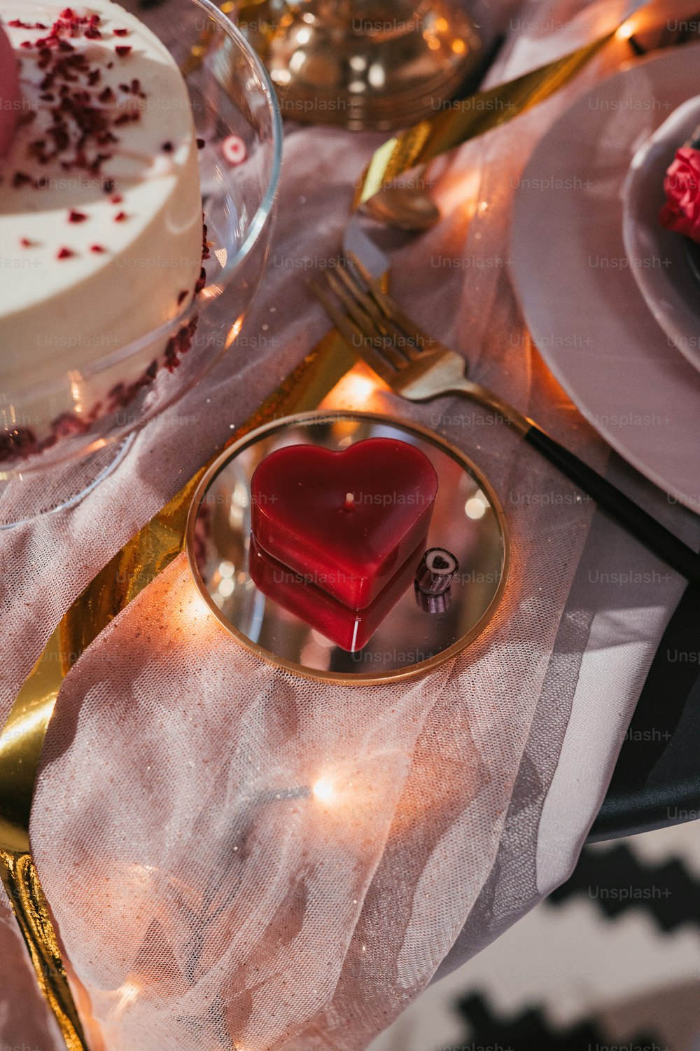 a table topped with a heart shaped cake